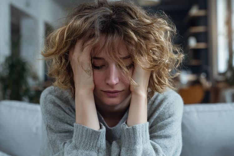 overwhelmed mom with her head in her hands