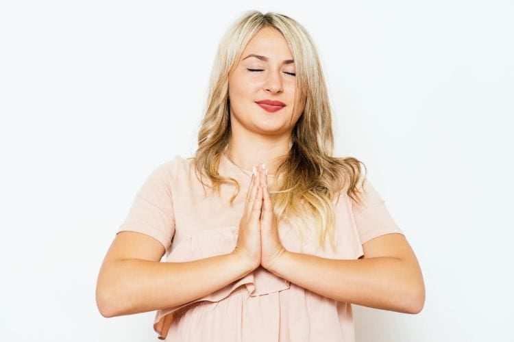 woman with her hands folded in prayer